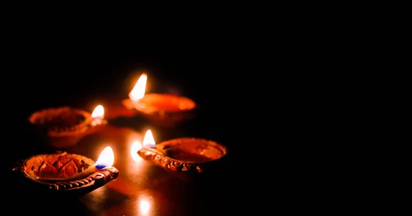 Lâmpada de óleo de barro acesa por ocasião do deepavali, um festival hindu de luz com foco seletivo na lâmpada e fundo e borrão de primeiro plano — Fotografia de Stock