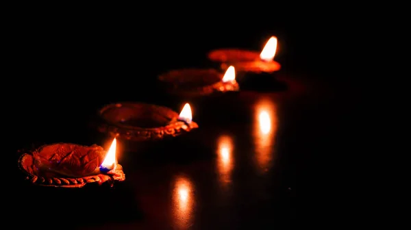 Lampada ad olio di terra accesa in occasione di deepavali, un festival indù di luce con focus selettivo su lampada e sfondo e sfocatura di primo piano — Foto Stock