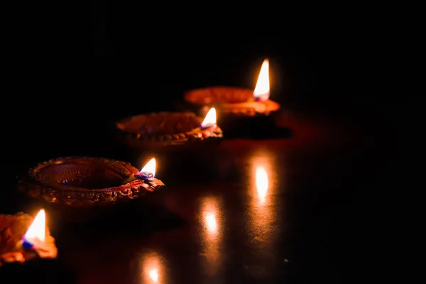 Lampada ad olio di terra accesa in occasione di deepavali, un festival indù di luce con focus selettivo su lampada e sfondo e sfocatura di primo piano — Foto Stock