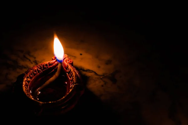 Lampada ad olio di terra accesa in occasione di deepavali, un festival indù di luce con focus selettivo su lampada e sfondo e sfocatura di primo piano — Foto Stock