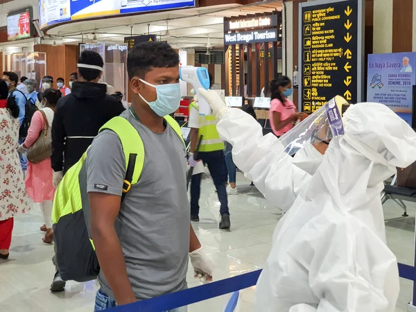 6 Haziran 20- Bagdogra Havaalanı, Siliguri, Batı Bengal, Hindistan-Hindistan yolcuları koruyucu teçhizatla Bagdogra Havaalanı 'ndaki havalimanı personeli tarafından covid taraması yapılıyor.