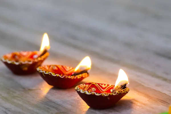 A set of 3 earthen oil lamp being lit at a temple during worship — Stock Photo, Image