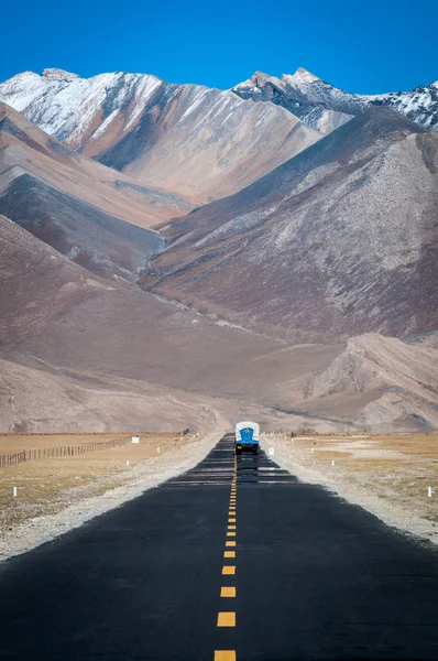 山に向かってまっすぐな道の先に運転トラック — ストック写真
