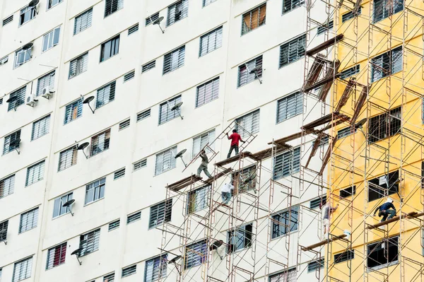 Workers painting a  high rise building without safety helmet and safety harness