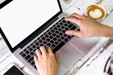 Genç eller latte kahve ile Laptop çalışma meşgul yan görünüm. ahşap masada oturan
