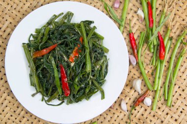 Kızarmış Sabah Zaferi 'ni örülmüş bambu masasında kırmızı biberli beyaz tabakla karıştır. Sağlıklı ve basit bir diyet. Bu menü hem restoranlar hem de sokak yemekleri için mevcuttur. Phrae Tayland.