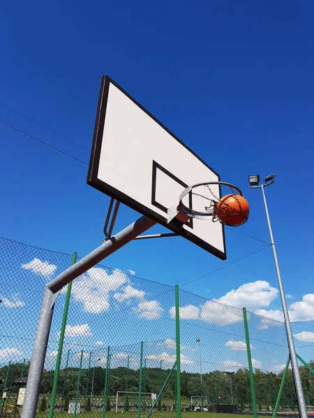 准确地投掷球入篮球圆环在体育场在露天在晴朗的晴朗的天 篮球场在露天与人造表面 举办团队运动 — 图库照片