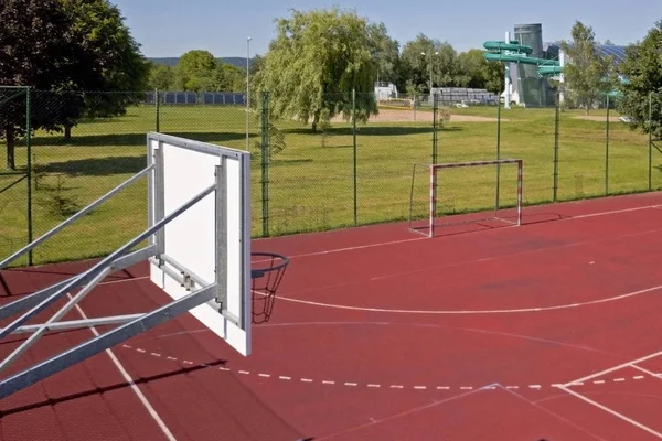 现代篮球场在小学的庭院 多功能儿童游乐场用人工表面围栏栅栏 儿童和青少年的体育教育场所 — 图库照片