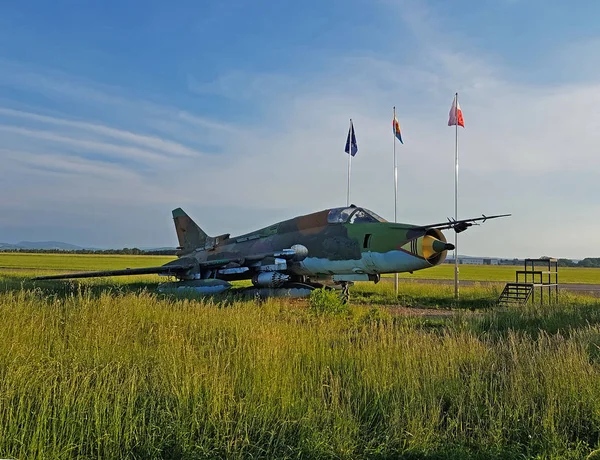 Military aircraft fighter at a grassy airfield. High technologies of the military industry. Romance of military specialty. Closed area on a sunny and clear day.