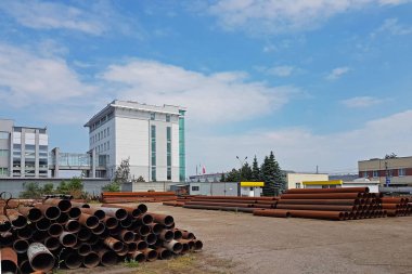 Bir ambar açık havada irili ufaklı metal boru. İnşaat sektörünün teknolojileri. Güzergah boyunca basınç altında sıvı taşıma. Kazı için metal parçalar.