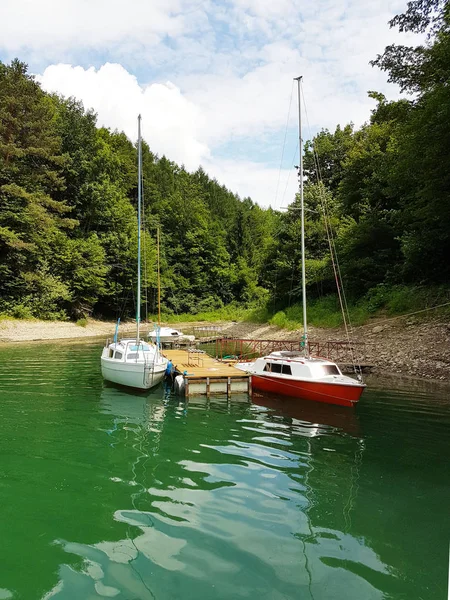 Small sailing yachts of coastal navigation are moored at the pier in a picturesque harbor. Prestigious and healthy lifestyle. Recreation and sports on the water. Yacht tourism industry. Natural resour