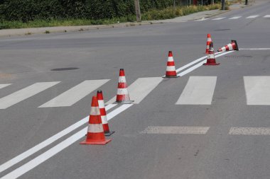 Hareketsiz değil ile çapraz dekore edilmiş yaya geçidi red kurumuş. Yol işaretleri tarafından trafik kısıtlama. Yaya yol işaretleri güncelleştirmek. Işıksaçan boya gri asfalt üzerinde. Erkekler iş başında.