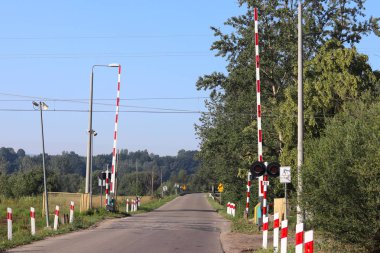 Bir bariyer ile demiryolu geçişi, yol işaretleri. Taşıma sistemi Avrupa ülke organizasyonu. Kırmızı beyaz boyama beklentili sis. Kara ve demiryolu ulaşım trafik güvenliği.