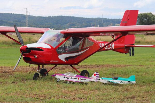 Yaslo, Poland - july 3 2018: Models of airplanes on the airfield stand near the light two-seater turboprop aircraft of red color. Airshow free time spending time for entertainment.