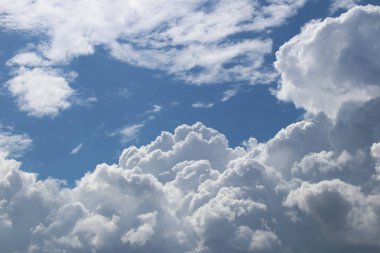 Kümülüs ve sirrus bulutlarıyla açık mavi gökyüzü. Güneşli bir hava. Neşeli bir ruh hali. Yüksek basınç. Temiz hava ekolojisi. Gaz halindeki bir su. Yağmur ve dolu kaynağı. Hava tahminleri.