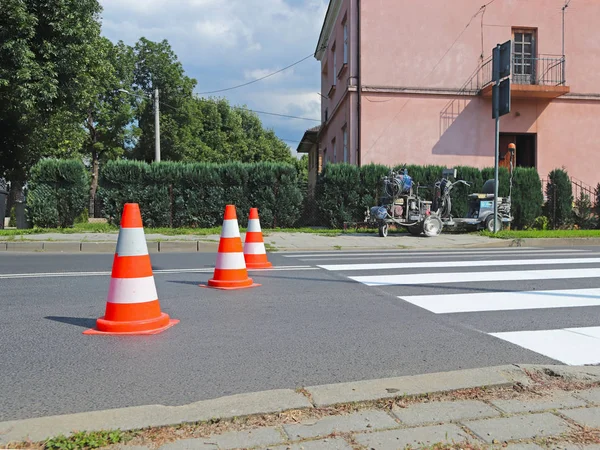 Marking with traffic signs a new colored pedestrian crossing. Restriction of traffic by road signs. A machine for drawing and updating road marking. Safety and rules of traffic