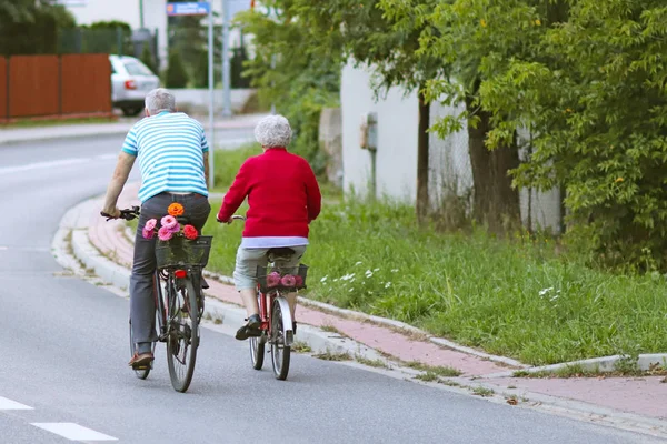 Reifer Mann Und Frau Fährt Fahrrad Unter Den Grünen Ein — Stockfoto