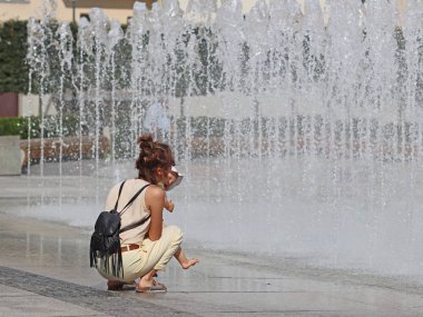 Rzeszow, Polonya - 9 Temmuz 2018: anne ve çocuk yakınındaki yaz şehir havuzun serinletici sıçraması. Banyo ve dinlenme gökkuşağı ışınlarının serbest zaman yaz tatilinde içinde