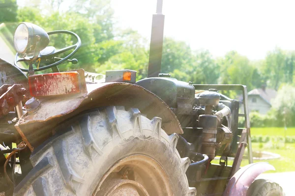 Old tractor in the rays of sunlight. Technologies of land cultivation in rural farming. Mechanization of manual labor. Mechanism with horsepower. Rural life and hard work.