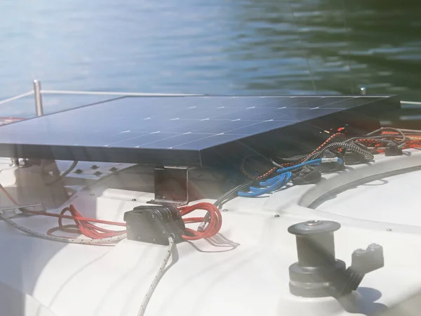 Solar battery for the development of electric current under the influence of sunlight mounted on the deck of a small sailing yacht. Electrification of the return on water during a tourist cruise.