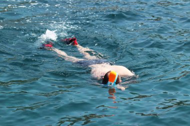 Genç bir çocuk dalış maskeli açık denizde yüzüyor. Modern teknoloji eğlence su. Mercan atolls genel bir bakış ve su altında nefes. Tatil ve Turizm sıcak ülkelerde.