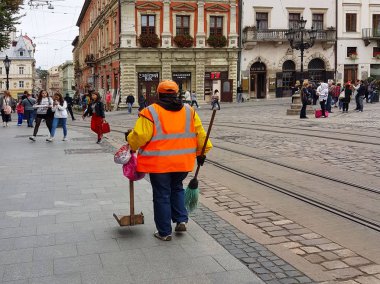Lviv, Ukrayna - 7 Ekim 2018: ortak ekonomi tarihi kentin merkezi kare piyasada çalışanı. Antik Mimarlık. Kentsel telaş. Bir turist rota. Temizlik ve atık yönetmek korumak