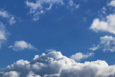 Kümülüs ve sirrus bulutlarıyla açık mavi gökyüzü. Güneşli bir hava. Neşeli bir ruh hali. Yüksek basınç. Temiz hava ekolojisi. Gaz halindeki bir su. Yağmur ve dolu kaynağı. Hava tahminleri.