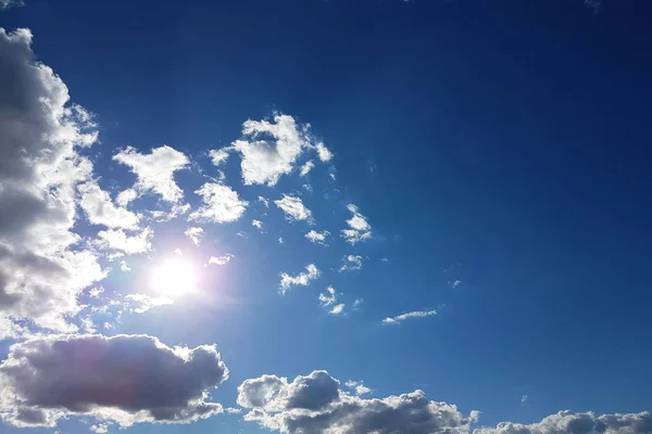 太陽は青い空の積雲を通して輝きます アーティストやデザインの背景やテクスチャ 目には明るい光 気体状態の水 自然界における流体の循環 — ストック写真