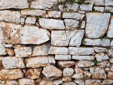 Antik Ortaçağ taş duvar. Doku duvar eski bir yapısının bir parçası. Tasarım ve yaratıcı çalışma için bir arka plan. Bina dış cephe süsleme ve dekorasyon. İnşaat işleri.