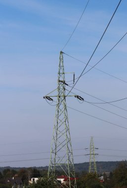 Fırtınalı bir gökyüzü, bulutlar çerçevede bir güneş tarafından aydınlatılmış bir yüksek voltajlı güç hattı. Enerji uzun mesafelere taşınması. Modernliğin yüksek teknoloji. Güç endüstrisi. Ekoloji.