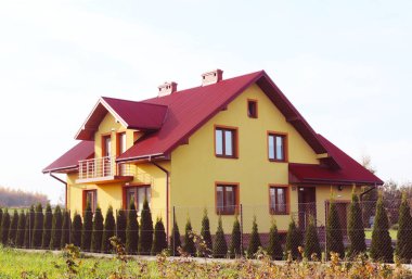 Jaslo, Polonya - 7 8 2018: Kırsal bir bölgede yer alan küçük bir müstakil ev Modern tasarımı. Binalar ve peyzaj tasarımı. İnsanlar için yeni ev. Kırmızı metal çatı. Enerji tasarrufu ve sera eff