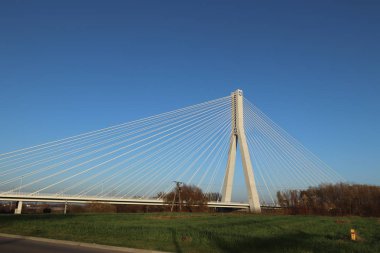 Rzeszow, Polonya - 99 2018: Wislok Nehri üzerindeki askıya alınmış yol köprüsü. Metal inşaat teknolojik yapısı. Modern mimari. Mavi arka planda beyaz bir haç şehrin bir sembolüdür..