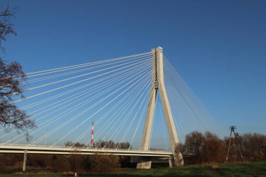 Rzeszow, Polonya - 99 2018: Wislok Nehri üzerindeki askıya alınmış yol köprüsü. Metal inşaat teknolojik yapısı. Modern mimari. Mavi arka planda beyaz bir haç şehrin bir sembolüdür..