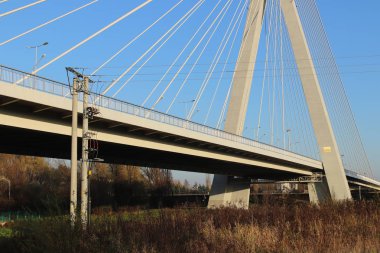 Rzeszow, Polonya - 99 2018: Wislok Nehri üzerindeki askıya alınmış yol köprüsü. Metal inşaat teknolojik yapısı. Modern mimari. Mavi arka planda beyaz bir haç şehrin bir sembolüdür..