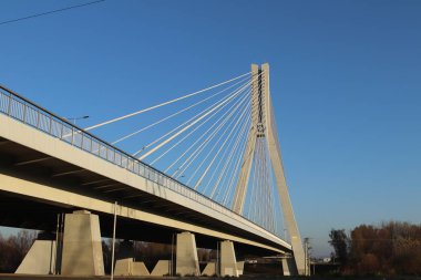 Rzeszow, Polonya - 99 2018: Wislok Nehri üzerindeki askıya alınmış yol köprüsü. Metal inşaat teknolojik yapısı. Modern mimari. Mavi arka planda beyaz bir haç şehrin bir sembolüdür..