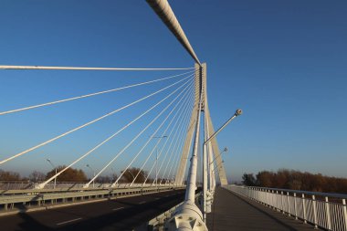 Rzeszow, Polonya - 99 2018: Wislok Nehri üzerindeki askıya alınmış yol köprüsü. Metal inşaat teknolojik yapısı. Modern mimari. Mavi arka planda beyaz bir haç şehrin bir sembolüdür..