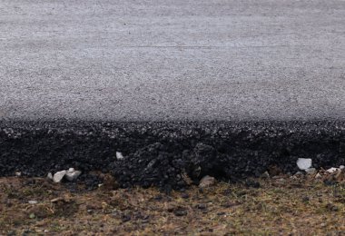 Parça taze moloz bir yastık üzerinde siyah asfalt koydu. Modern teknoloji araçları ve yayalar için katı kaplama. Otoyol İnşaatı unsurları. Parçalı yapı taşlarının