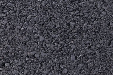 Koyu siyah arka plan haddelenmiş asfalt keşfedemiyoruz. Araçlar ve yayalar için katı kaplama modern teknolojiler. Otoyol İnşaatı unsurları. Fındıktan küçük taneli yapısı