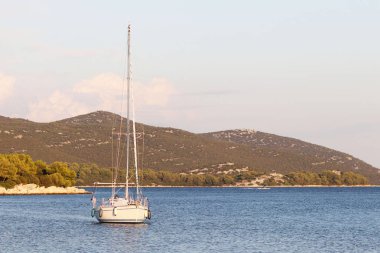 Bir Yelkenli tekne bir koyda demirlemiş olan. İnsanlar denizde yıkarım. Akdeniz Bölgesi Adriyatik Denizi üzerinde aktif dinlenme. Dalmaçya riviera Hırvatistan. Prestijli ve zengin yaşam tarzı