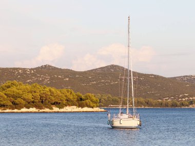 Bir Yelkenli tekne bir koyda demirlemiş olan. İnsanlar denizde yıkarım. Akdeniz Bölgesi Adriyatik Denizi üzerinde aktif dinlenme. Dalmaçya riviera Hırvatistan. Prestijli ve zengin yaşam tarzı