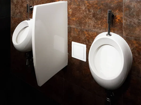浴室内部为黑色和白色 椭圆形陶瓷小便池 厕所后洗手用的镜子 塑料肥皂盘和镀铬水龙头 使用深色瓷砖进行设计 — 图库照片