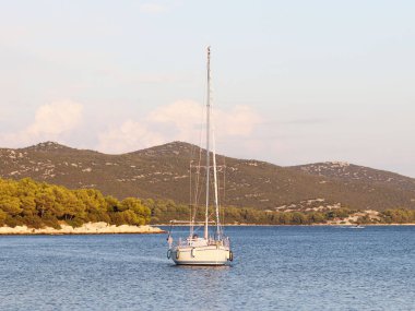 Bir Yelkenli tekne bir koyda demirlemiş olan. İnsanlar denizde yıkarım. Akdeniz Bölgesi Adriyatik Denizi üzerinde aktif dinlenme. Dalmaçya riviera Hırvatistan. Prestijli ve zengin yaşam tarzı