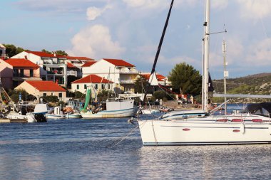 Kaprije, Hırvatistan, Avrupa - 7 9 2018: Adriyatik Denizi küçük bir Hırvat kasabada çıkabilir. Dalmaçya Riviera arka plan üzerinde Yelkenli Yat. Turizm ve Akdeniz mimarisi.