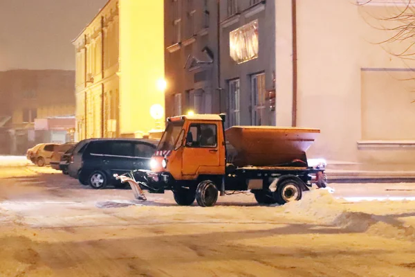 一辆装有大型推土机的技术服务车将城市道路从雪中清理干净 并撒上沙子 由于晚城的一场雪灾 打开了这条通道 冬季阻塞 — 图库照片