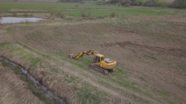 Debowiec, Polonya - 24 Nisan 2018: Kazıcı çöp kamyonunu toprakla dolduruyor. Arazi nehir çakıl ocağında çalışıyor. Doğal kaynakların çıkarılması. Çevrenin korunması. Parlak Gelecek. 