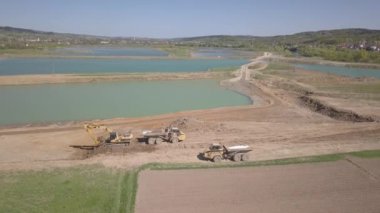 Vislock Nehri, Polonya - 2 Mayıs 2018: Ekskavatör damperli kamyon toprak ile yükler. Kara nehir çakıl ocağında çalışıyor. Droning sinek Cat.Panorama tarafından üretilen özel bir teknik çalışma