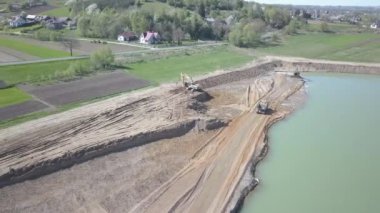 Vislock Nehri, Polonya - 2 Mayıs 2018: Ekskavatör damperli kamyon toprak ile yükler. Kara nehir çakıl ocağında çalışıyor. Droning sinek Cat.Panorama tarafından üretilen özel bir teknik çalışma
