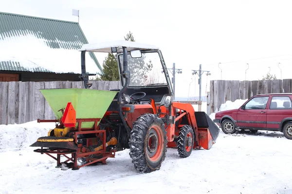 The tractor pours snow with his bucket on the ski slope. The work of the snowcat in the winter time. Preparation of the sports ground for competitions. Snow drifts and mechanization in working with