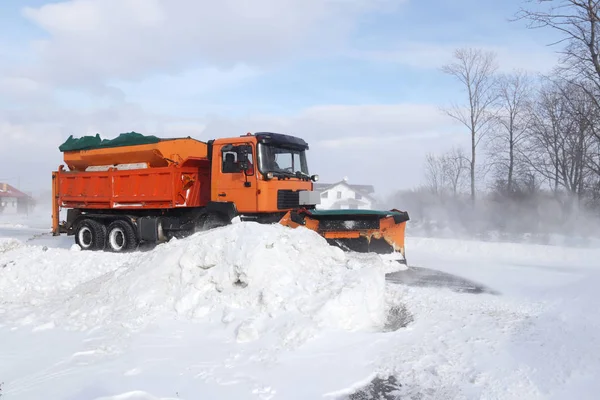 一辆有犁的大车把道路从雪中清理干净 橙色货物专用设备在冬季与元素作斗争 消除雪灾的影响 交通困难 冷冻水 — 图库照片