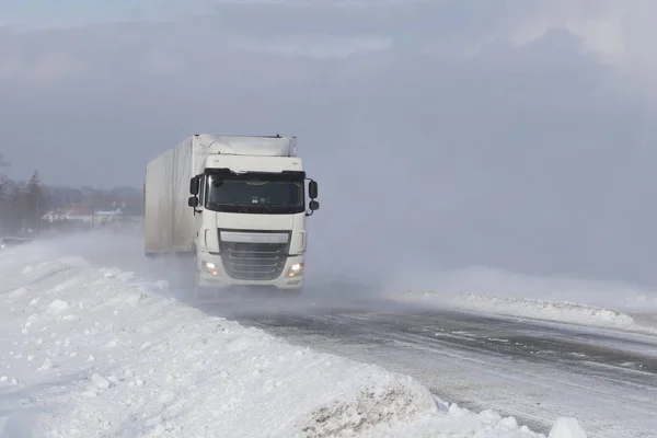 一辆大卡车在一条被雪覆盖的危险道路上偷偷穿过雪堆 Tir 与冬季元素作斗争 雪灾期间交通困难 寒冷天气和水的后果 — 图库照片